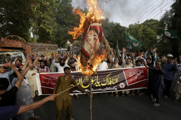 Supporters of a religious group burn a picture of Nupur Sharma, a spokesperson of the governing Indian Hindu nationalist party during a demonstration to condemn derogatory references to Islam and the Prophet Muhammad recently made by Sharma, Sunday, June 12, 2022, in Lahore, Pakistan.