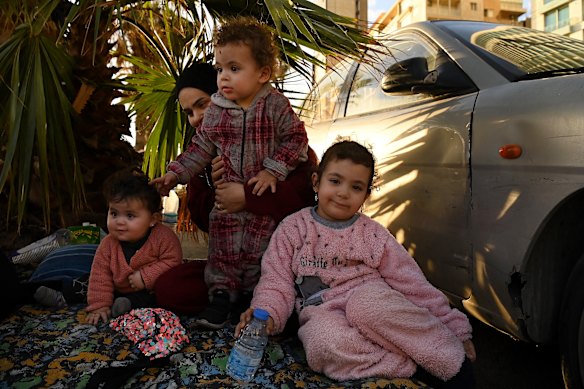 Zainab al Mawla and her children – Alaa, 11 months, Ali, 2, and Baloul, 4 – smile and play on the rug that is now their temporary home.