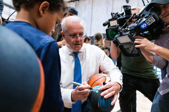 Scott Morrison, basketball in hand after a stray ball knocked off his glasses while campaigning in Victoria.