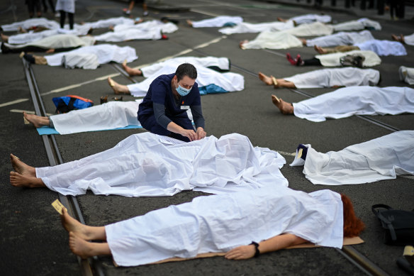 Some participants lay covered in white sheets.