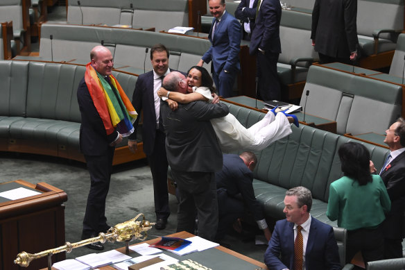 Liberal MP Warren Entsch lifts up Labor MP Linda Burney as they celebrate the passage of marriage equality legislation on December 7, 2017.