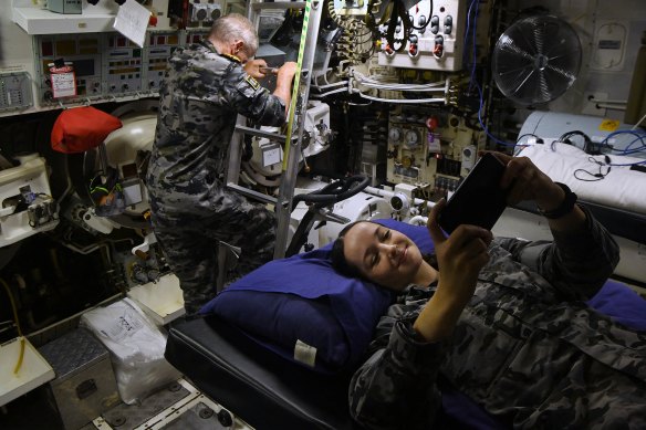 Submariner Able Seaman Sophie rests on a bunk where torpedoes are also stored onboard the HMAS Rankin.