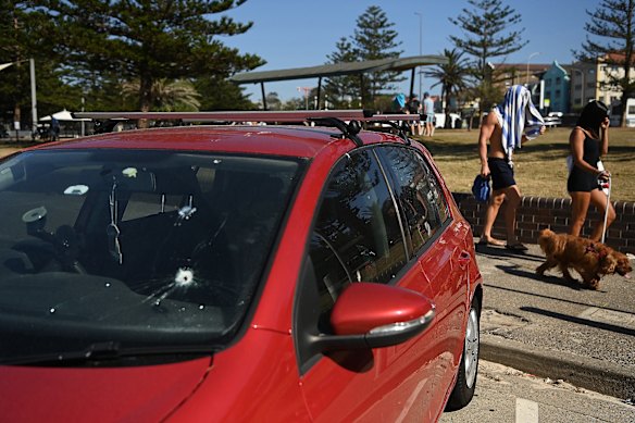 A bullet hole in the window of a red VW Golf vehicle parked on the beachside of Archer Park in Bondi.