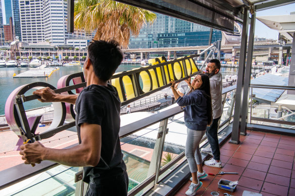 Shivi and Avi Prabhakar (pictured centre and right) were emotional as they took down the sign for their restaurant, Zaaffran, which opened at the Harbourside shopping centre at Darling Harbour in 1998.