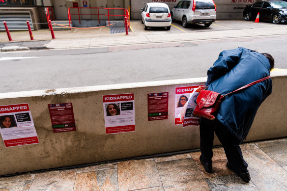 A North Sydney Council employee removing illegally placed posters highlighting the hostages believed to be held by Hamas in Gaza.