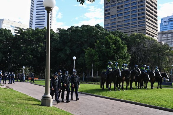 Police and mounted police wait in the empty Hyde Park.