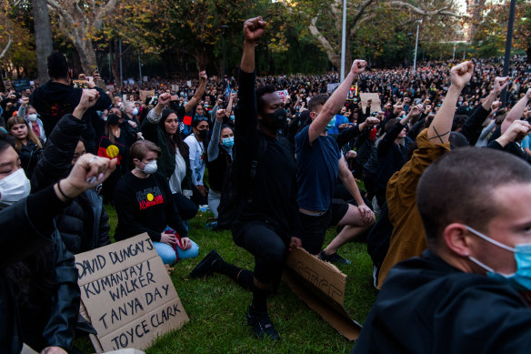 Thousands of protesters kneel and salute at a Black Lives Matter.