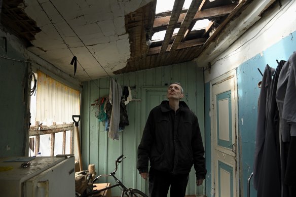 Serhiy Okhonenko, 47, looks up at remains of his roof, destroyed by this week’s Russian attacks. 