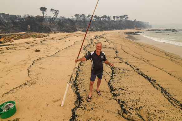 Fisherman Brett Mayor, from Melbourne, was the only person on the ash-covered beach.