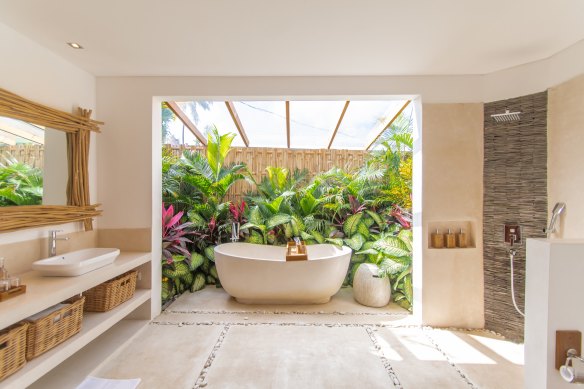 Enjoy a soaking session in a lush indoor-outdoor garden.