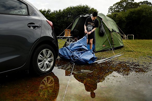 Jack Sultana packs up his rain-soaked camp site at Bents Basin State Conservation Area near Wallacia on Friday.