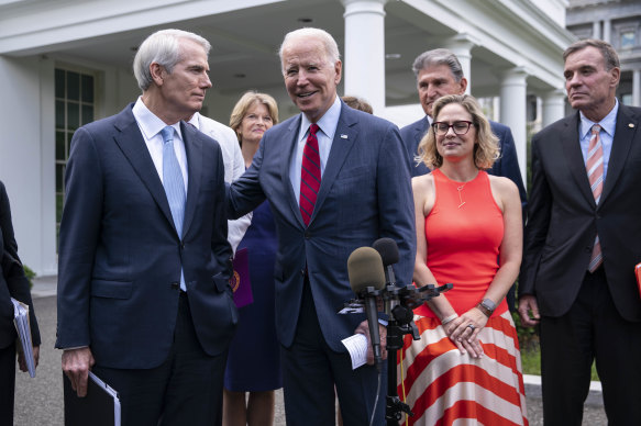 Not always all smiles: US President Joe Biden, centre, addresses a group of senators including Senator Kyrsten Sinema.