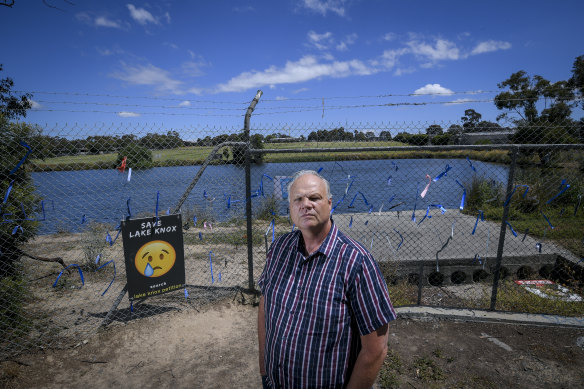 Dr Mark Glazebrook, from Friends of Lake Knox Sanctuary, stands in front of the fence that locals have covered in blue ribbons.