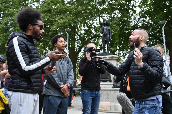 A man (right) argues against the new sculpture, by local artist Marc Quinn, of Black Lives Matter protester Jen Reid. 