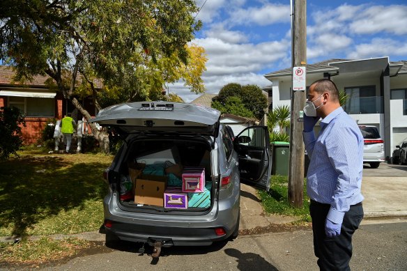 Bilal El-Hayek takes a phone call outside a Greenacre home while Aner Yassine delivers food to a household of 10.