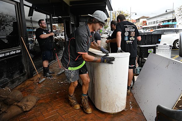 Locals start cleaning out shops and businesses along Pulteney Street in Taree.