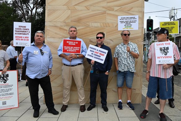 Dallas Morgan, third from left, was among those holding protest signs at the school’s entrance.