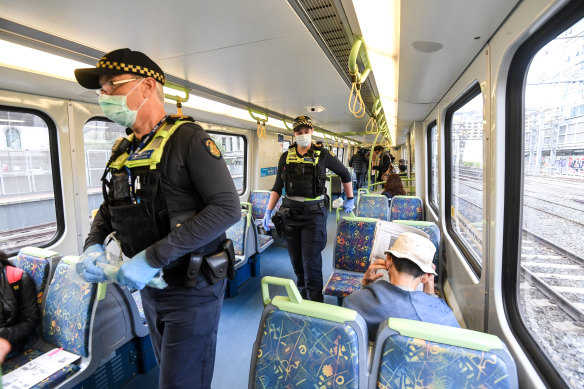 Protective services officers wearing masks on a Melbourne train. 
