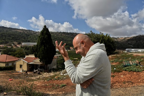 Chicken farmer Eytan Davidi at his farm in Margaliot on the border with Lebanon, which can be seen in the background.