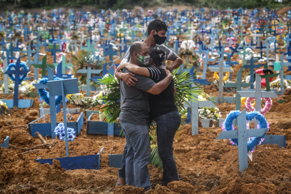 People mourn their relative at a Manaus cemetery where hundreds of COVID-19 victims have been buried.