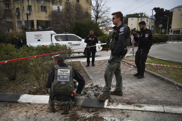 Israeli security forces examine the site hit by a rocket fired from Lebanon, in Kiryat Shmona.