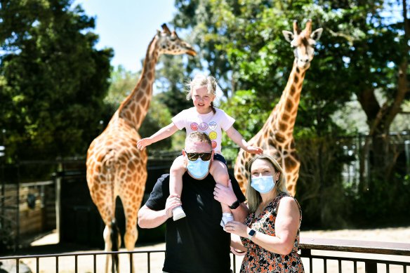 A family visiting the giraffe exhibit at Melbourne Zoo last year. 