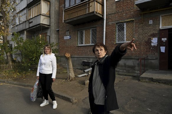 Valentyna Khazan, 55, and Olena Siyanko, 71, (right) stand in front of their apartment building that remains intact after it was impacted by a S300 missile strike.