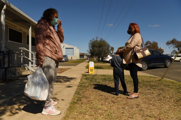 Members of the Boney family wait for other relatives outside the Ochre medical centre in Brewarina.