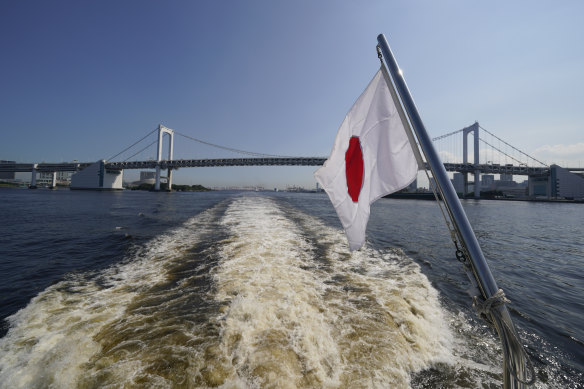 The Japanese flag flies from the stern of a cruise boat during a media tour of Tokyo Bay ahead of the start of the Summer Olympics on Monday.