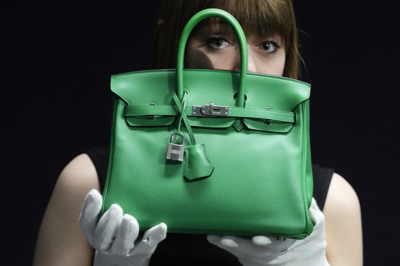 An auction house employee displays a  Bambou Swift Leather Birkin 25 bag in London.