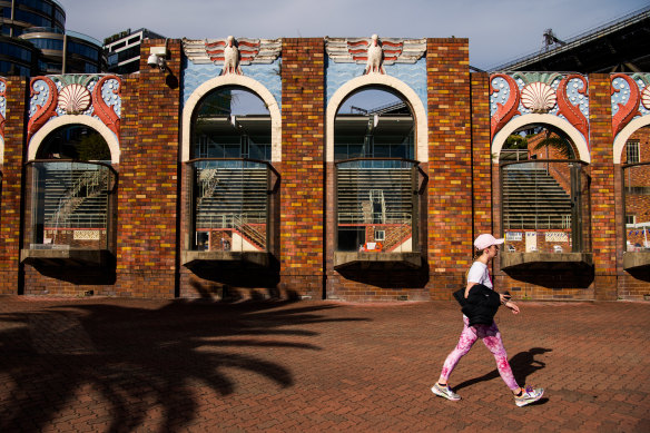 A pedestrian passes the art-deco brick wall that borders North Sydney Olympic Pool, on the edge of Sydney Harbour, on Tuesday.