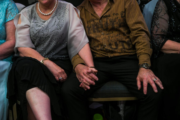 A couple holds hands as they take a break from dancing.