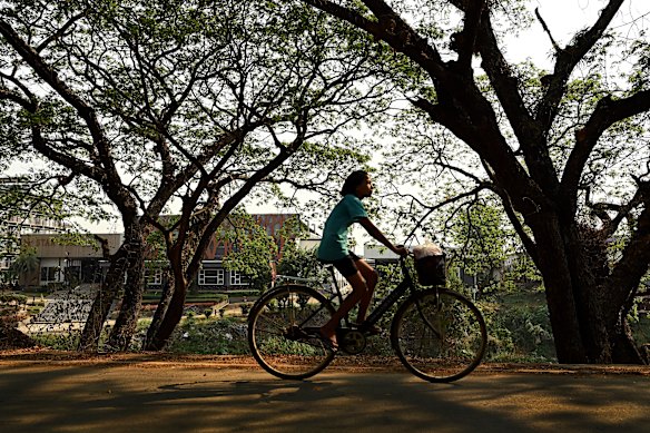 A girl rides her bike along a road on the Thailand side of the Moei River in Mae Sot, across from Myanmar.