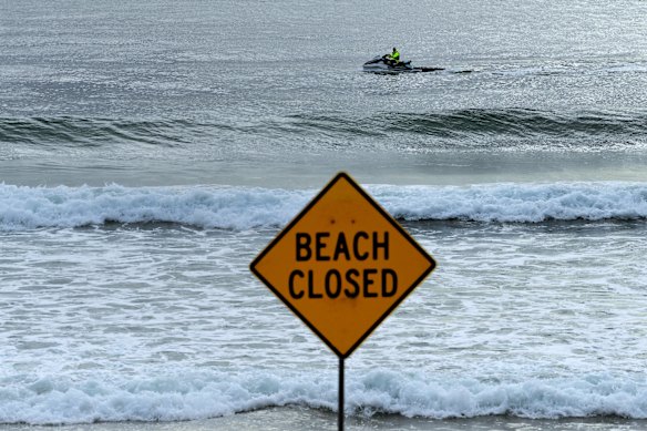 Uma placa de fechamento de praia em North Steyne Beach após outro ataque de tubarão na segunda-feira.
