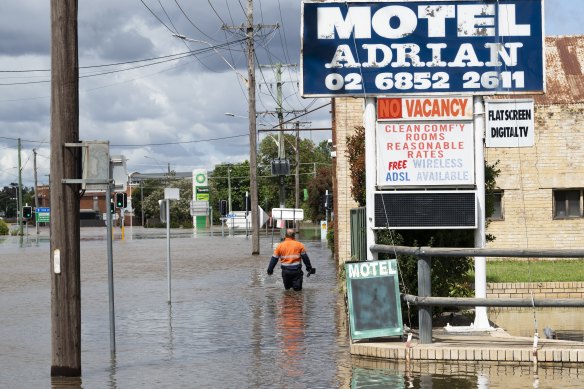A man navigates floodwater in Forbes today. The flooding is predicted to peak on Thursday.