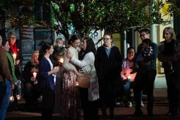 Sophie Roome is comforted by family, friends and the community of Lismore at a vigil for her son Rowan, 2, who was murdered by his father last Sunday.