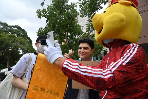 Pavlou poses outside court with supporters. Police are pushing ahead with one charge of failing to comply with directions.