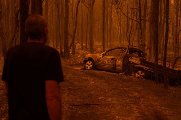 Grant looks at the burnt car he tried to escape in.