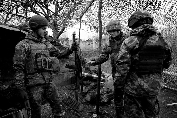 Soldiers in Ukraine’s 30th Brigade discuss their weaponry in a trench in the Donbas region.