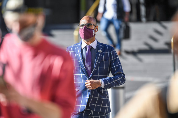 Mask-wearing is again becoming more widespread. A masked man is here pictured crossing the road outside Melbourne's Flinders Street Station.