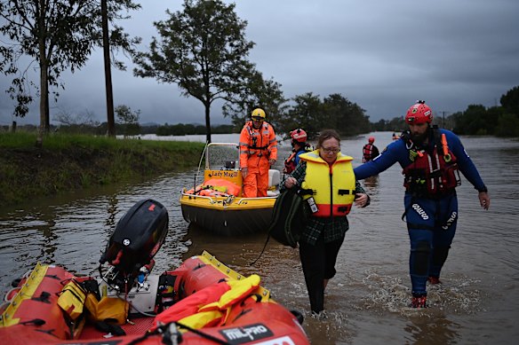 A woman being rescued by a Fire and Rescue NSW team near Taree.
