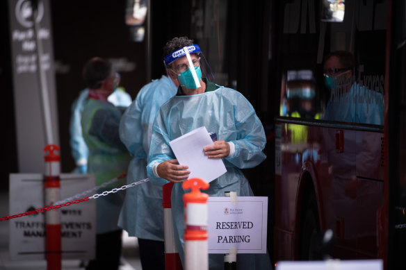 Hotel quarantine workers wearing full protective equipment at the Pan Pacific in South Wharf on Monday.
