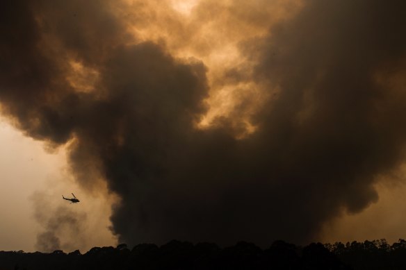 A water bombing helicopter races along the flank of the Grose Valley Fire in December.