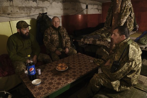 Major Vyacheslav Kokhanov, right, battalion commander with the 68th Brigade, talks with his officers at their forward headquarters.