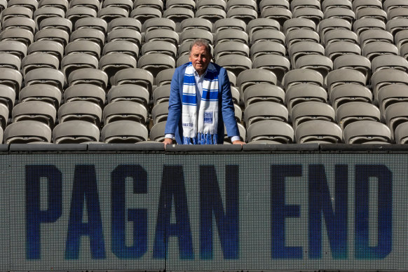 Former North Melbourne coach Denis Pagan poses with a Pagan End sign at Marvel Stadium.