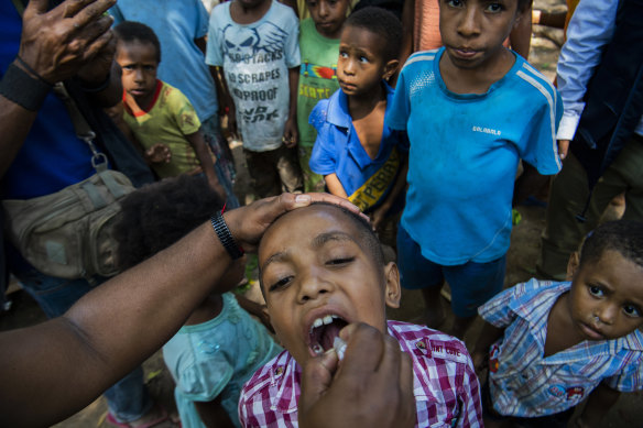 A child in Papua New Guinea receives a polio vaccine. The coronavirus outbreak threatens to reverse decades of global progress in alleviating poverty.