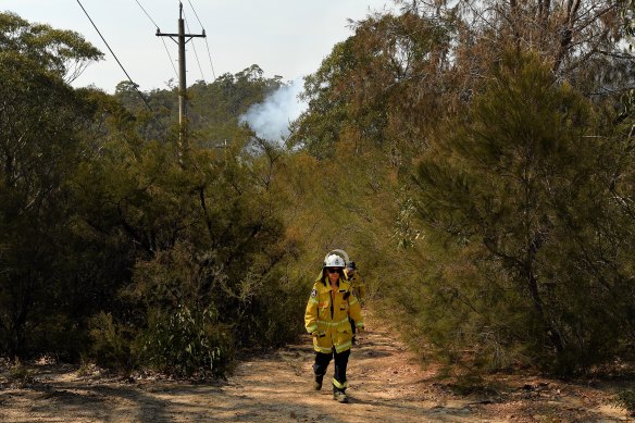 NSW RFS  volunteers in Tahmoor walk out of the bush after checking on the fire, which is a part of the Green Wattle Creek blaze.