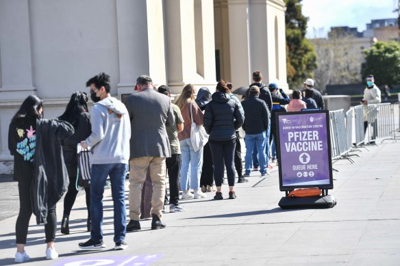 People queue to be vaccinated at the Royal Exhibition Building in Carlton on Saturday. 