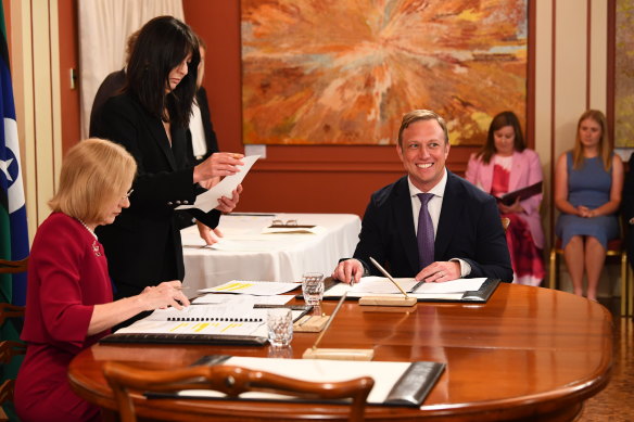Incoming Premier Steven Miles (right) looks on as the Governor, Dr Jeannette Young (left) signs papers during a swearing-in ceremony at Government House Queensland in Brisbane on Friday.