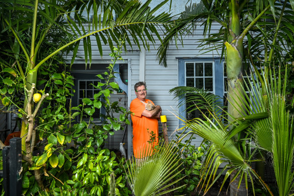 Matt Callander, with cat Sam, has lived in the suburb for more than a decade and helped battle the council so he could plant trees that blocked out the train line.